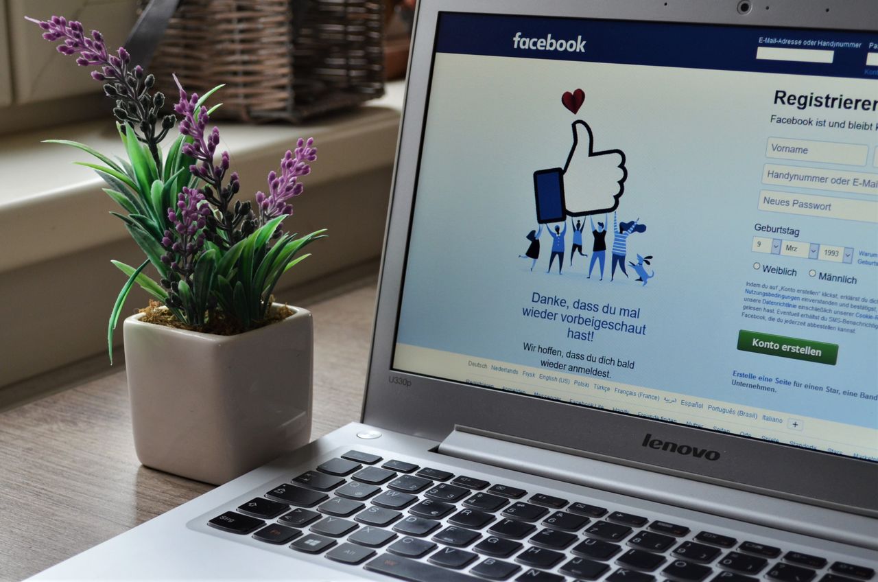 about-us-01 A Lenovo laptop displaying Facebook login beside a lavender plant indoors.